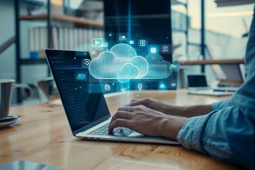 Otevřený notebook s holografickým zobrazením cloudu a ikon služeb nad klávesnicí.