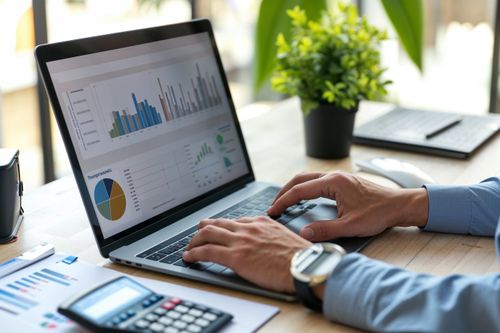 Laptop s grafy a diagramy na obrazovce.